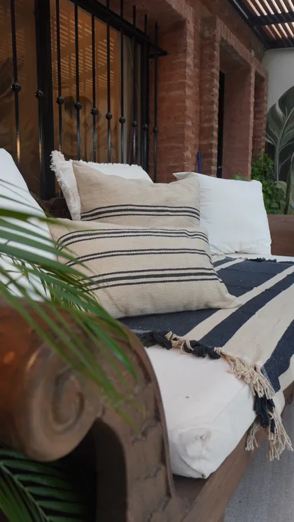 Living exterior con sillones a rayas y pared de ladrillo — proyecto Deco Jardín, por cipresdecoargentina7377, en San Isidro