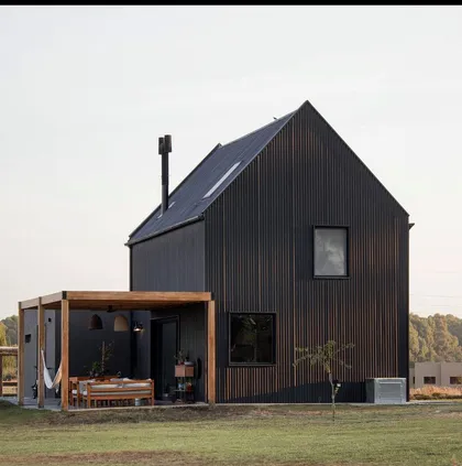 Casa moderna negra con pérgola de madera y exterior rural — proyecto Cabin , por Grupo Steimberg , en Pilar