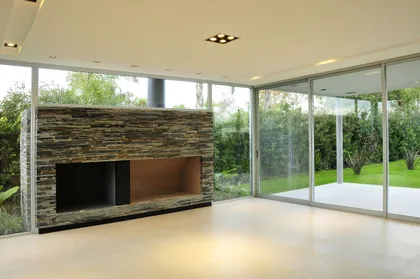 Living moderno con chimenea de piedra y ventanales — proyecto Casa EP, por Santiago Cordeyro Arquitectos, en Del Viso