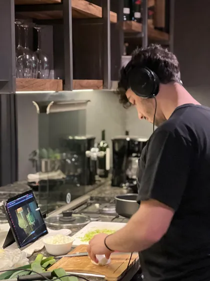 Cocina moderna industrial con persona cocinando con auriculares — proyecto Casa CE, por Estudio FORSCH, en Pinamar