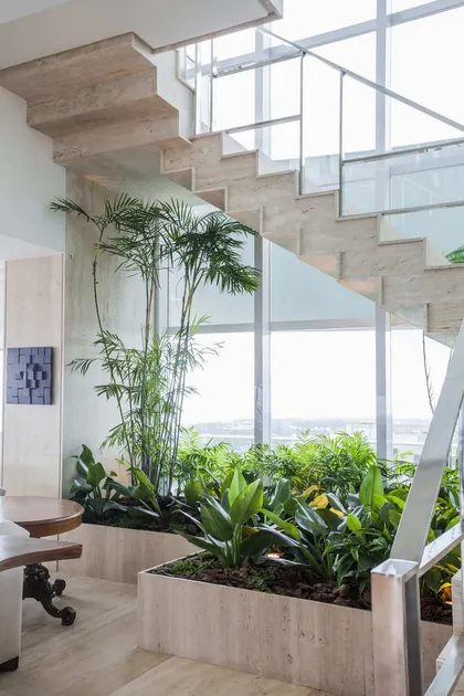 Escalera moderna con jardín vertical integrado y gran ventanal — proyecto Cobertura LS, por Patrícia Marinho Arquitetura