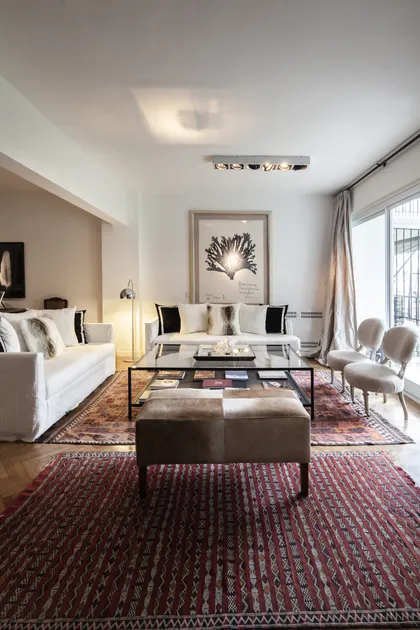 Living moderno con sofá blanco, tapete bordo y arte minimalista en pared — proyecto GO2219, por Facundo Arana Arquitecto