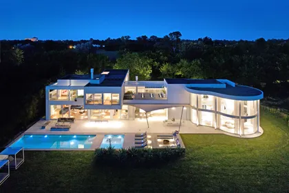 Fachada moderna con piscina infinita y muros curvos de vidrio — proyecto OX8 - Casa en Martindale, por MLS Estudio, en Martindale Country Club