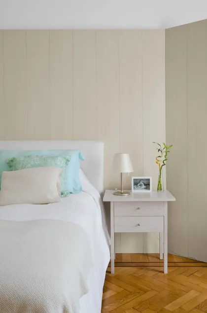 Dormitorio minimalista con cama blanca y mesa de noche, pared panelada — proyecto Dpto LH, por Estudio Dado, en Recoleta