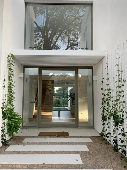 Fachada moderna con amplios ventanales, jardín vertical y pérgola — proyecto CASA BECCAR, por Estudio Xime Fontan Balestra, en Béccar