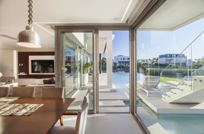 Living comedor moderno con vista a la piscina y al mar — proyecto Casa Caledoiscopio, por Apaarquitectura, en Nordelta