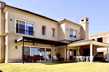 Galería exterior con pérgola de madera y ventanales en casa moderna — proyecto Los Alisos 3 Nordelta, por Marconi Silva Arquitectos, en Los Alisos