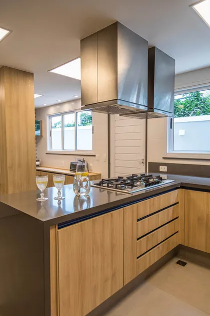 Cocina moderna con isla madera, mesada gris y ventanal amplios — proyecto Casa Barra ED, por Amanda Miranda