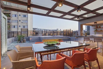 Terraza moderna con pérgola de madera y vista urbana — proyecto COBERTURA G|JM, por Chris Coelho Arquitetura 