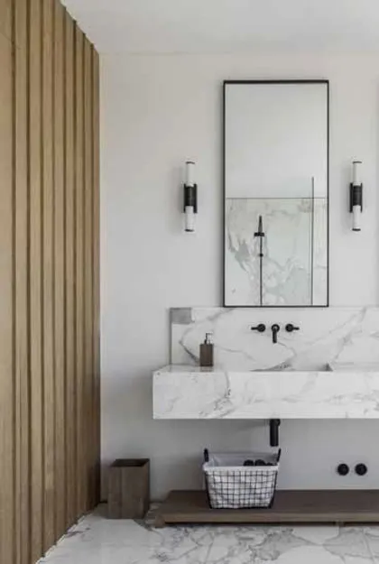 Baño moderno con pared de listones de madera y mármol — proyecto Pilará, por Martin Gomez, en Pilará