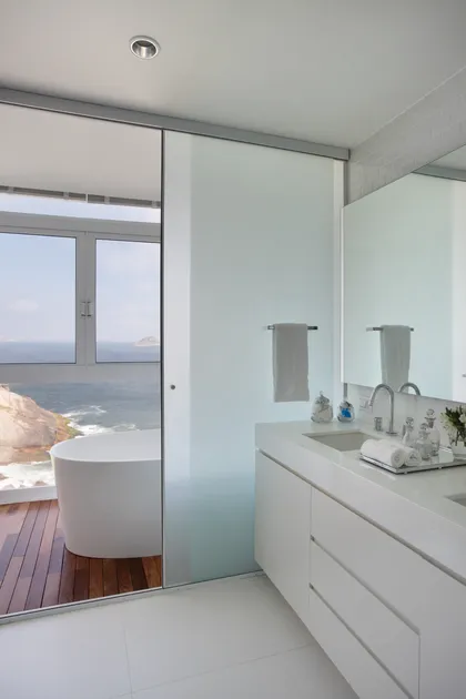 Baño moderno con bañera exenta y vista al mar, tocador minimalista — proyecto Casa CB, por AR.KITEKT