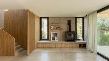Sala de estar moderna con estufa de leña y paneles de madera — proyecto CASA CC, por Rastro Estudio, en San Isidro