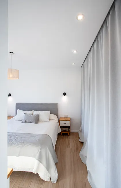 Dormitorio moderno con cortinas blancas y luz natural — proyecto SS45, por EZ architects, en Pilar
