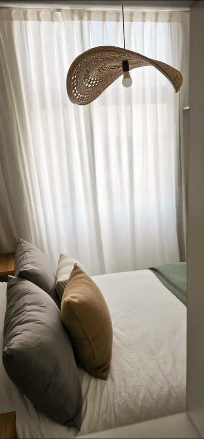 Dormitorio estilo boho con lámpara colgante de ratán tejida — proyecto Callao, por Claraboia , en Recoleta