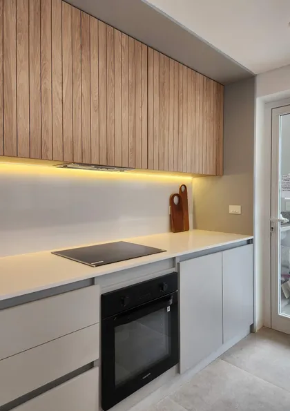 Cocina moderna con muebles de madera y luz indirecta — proyecto Acacias 265, por BARBALACO ARQUITECTOS, en Belén de Escobar