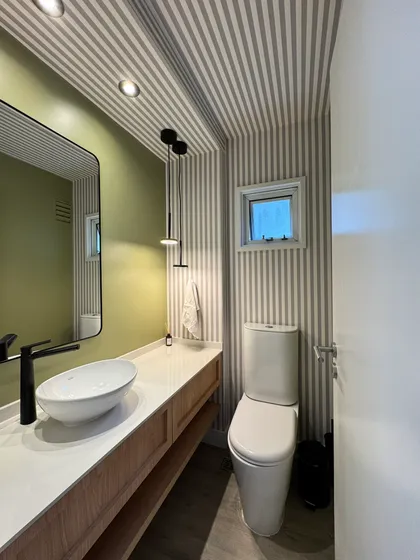 Baño moderno con papel rayado y tocador de madera — proyecto Lafinur, por MDBK Arquitectura, en Palermo