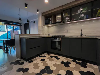 Cocina moderna con muebles grises oscuros y piso hexagonal — proyecto Vivienda Mari y Lean, por Jeitinho Estudió Creativo, en La Plata