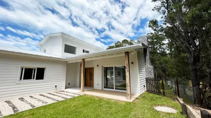 fachada de casa moderna blanca con detalles en madera y ventanas amplias — proyecto Casa Luvir - Barrio Costa Esmeralda (Partido de la Costa, Buenos Aires) German S, por German Sal