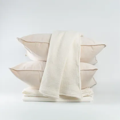 Pillows y manta doblada en tonos neutros sobre cama — proyecto Total White./01, por Mara Fuhr, en Núñez