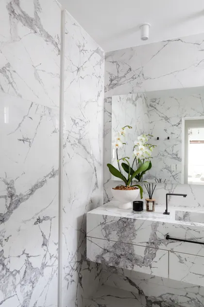 Baño moderno con mármol veteado y tocador flotante — proyecto Alvear | Redefining luxury, por Ren Studio, en Recoleta