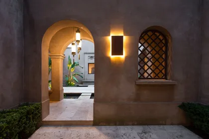 Entrada arqueada con iluminación cálida y ventana de celosía — proyecto Casa MJ, por Ricardo Pereyra Iraola