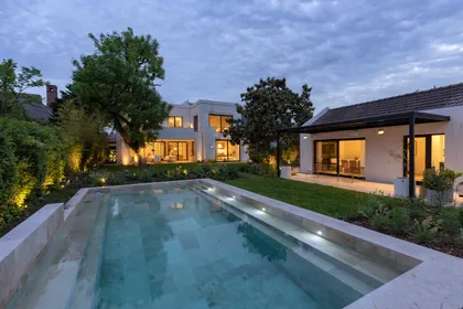 Casa moderna con piscina iluminada al atardecer — proyecto Las Marías, por Santiago Cordeyro Arquitectos, en San Isidro