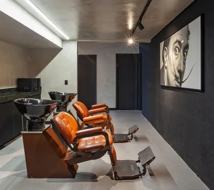 Pasillo contemporáneo con escalera naranja y retrato artístico en pared negra — proyecto SCHAPER BARBEARIA, por Frederico Bicalho Arquitetura