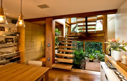 Escalera de madera con doble altura, plantas colgantes y luminarias pendant — proyecto Casa A.L., por Ruschel Arquitetura e Urbanism
