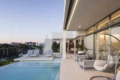 Piscina infinita con sillones colgantes y terraza moderna — proyecto Casa Caledoiscopio, por Apaarquitectura, en Nordelta