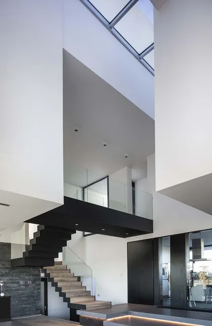 Escalera flotante moderna en espacio de doble altura con tragaluz — proyecto 291, por Remy Arquitectos