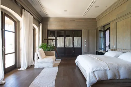 Dormitorio principal luminoso con piso madera, ventanales y techo revestido — proyecto Casa Toscana , por Estudio Du