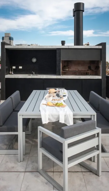 terraza moderna con cocina exterior y zona de comedor — proyecto Teodoro, por Claraboia , en Belgrano R