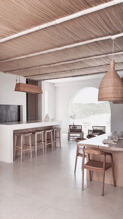 Cocina moderna mediterránea con isla de concreto y techo de paja — proyecto El Refugio, por Grupo Pauta Arquitectura, en Pinamar