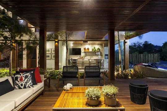 Terraza moderna con deck de madera, pérgola y vista a pileta — proyecto Varandas, por Xico Diniz