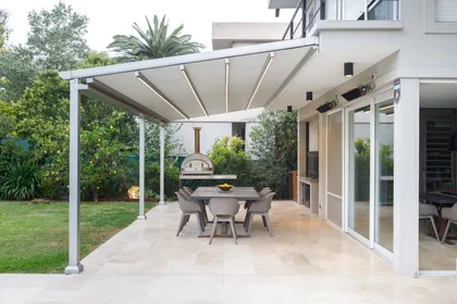 Parrilla moderna con pérgola retráctil y comedor exterior — proyecto TOLDER - PERGOLAS, por Argentina en Obra 2024, en Rincón de Milberg