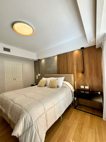 Dormitorio moderno con paneles de madera y luz indirecta — proyecto Olleros, por MDBK Arquitectura, en Belgrano