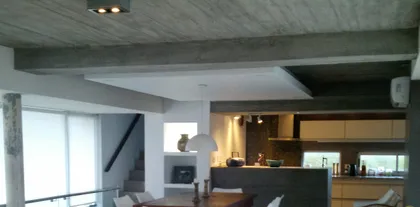 Cocina comedor moderna con vigas y hormigón visto — proyecto VILLA ESMERALDA, por GJF estudio, en Pinamar