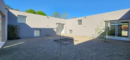 Fachada moderna con patio central y detalles minimalistas — proyecto Casa VAL, por Estudio Rifahi, en Capilla del Señor