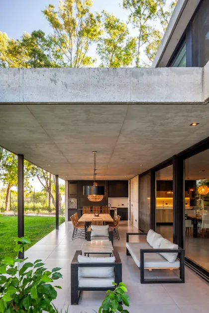 Pérgola moderna de hormigón con comedor y estar exterior — proyecto Casa ALVA, por V2 Arquitectos, en City Bell