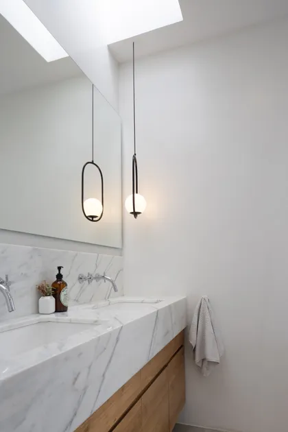 Baño moderno con doble bacha, luces colgantes y claraboya — proyecto CASA OrAz, por Alfredo Orfila arquitectura, en San Isidro