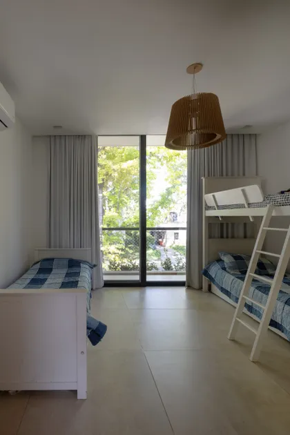 Dormitorio moderno con dos camas, litera y vista al jardín — proyecto CASA RuZa, por Alfredo Orfila arquitectura, en Benavidez