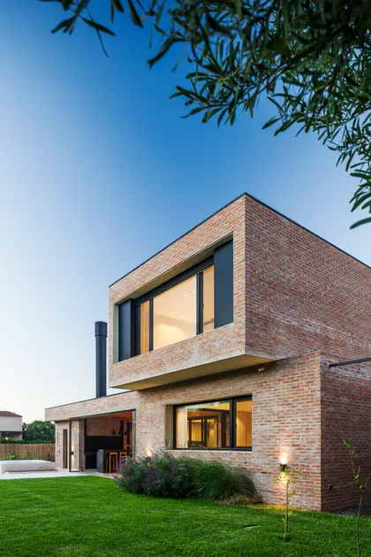 Casa moderna de ladrillos con grandes ventanales y jardín — proyecto Casa Brick, por LSA. , en Pilar