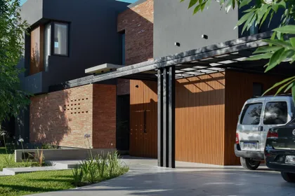 Fachada moderna con hormigón, madera y grandes ventanales — proyecto CASA HC, por Daniel Daniele - Oficina de Arquitectura, en Canning