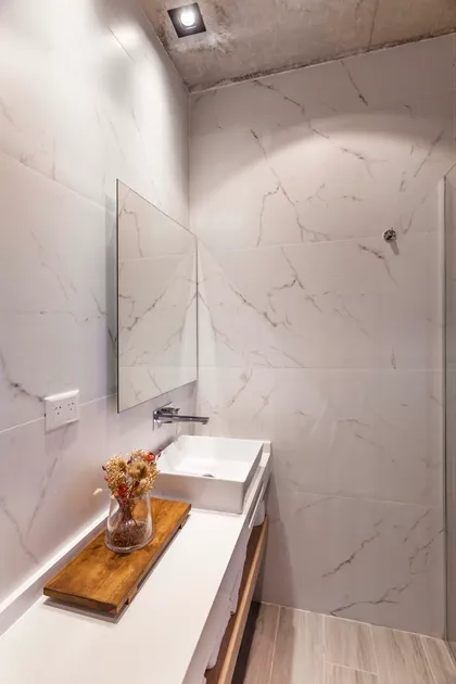 Baño moderno con pared marmolada y techo de hormigón — proyecto DISEÑO INTERIOR - CASA VISTAS, por FOCO_arquitectura&diseñointerior, en Belén de Escobar