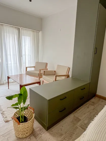Sala de estar moderna con muebles de madera verde oliva y estilo mid-century — proyecto Reforma para alquiler temporal, por Gisela Salis, en Mar del Plata