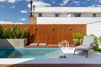 Piscina moderna con deck de madera y vegetación exuberante — proyecto Casa Condomínio Atmosfera - Arq Patrícia Mariante, por Tita Leke Fotografia