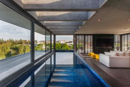 Piscina interior moderna con living integrado y vistas — proyecto Water House, por Remy Arquitectos, en Rincón de Milberg