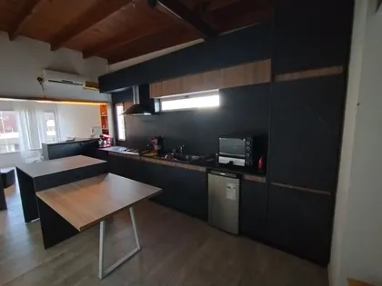 Cocina moderna con isla, gabinetes negros y detalles en madera — proyecto Diseño personalizado a gusto del cliente , por Saavedra Amoblamientos , en Pinamar