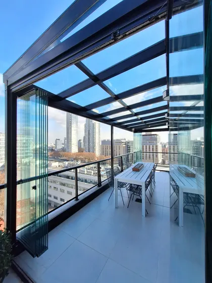Terraza moderna acristalada con vistas urbanas y mesa de comedor — proyecto TOLDER - CERRAMIENTOS, por Argentina en Obra 2024, en Rincón de Milberg