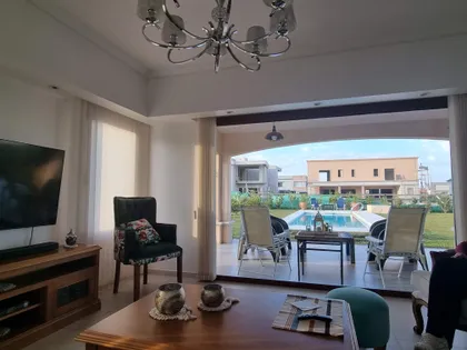 Living comedor con vista a la piscina y mucha luz natural — proyecto Casa El Rebenque, por Arq. Leonardo De Lorenzi , en Canning
